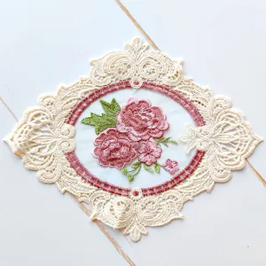 Detailed macro shot of vintage floral embroidered lace patch with pink rose motifs