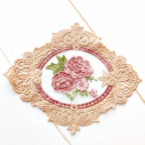 Detailed macro shot showing the fine texture of pink floral embroidery and beige lace.