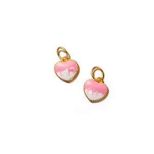 Détail macro du pendentif coeur en argent doré avec émail rose dégoulinant