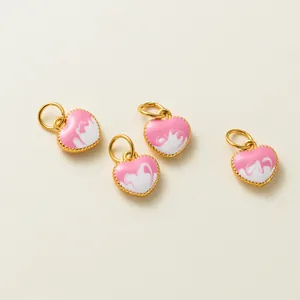 Détail de breloques cœur rose plaqué or avec effet émail marbré pour la création de bijoux