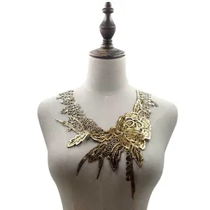 Detailansicht der goldfarbenen Spitzenstickerei mit Blumen auf einem Schaufensterpuppen-Torso