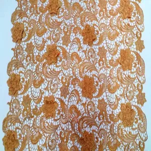 Détail en gros plan d'un tissu en dentelle dorée hydrosoluble avec broderie 3D fleur