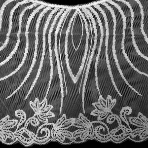 Close-up view of white water-soluble lace collar with embroidery detail on mesh base