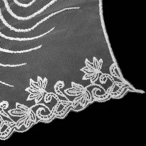 Detailed macro view of white water-soluble floral lace embroidery on fine mesh net