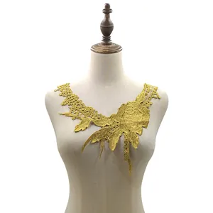 Detailansicht eines goldfarbenen, wasserlöslichen Spitzenblumen-Applikationskragens auf Torso