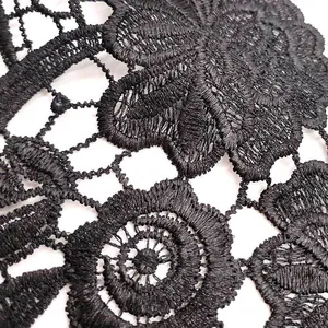 Détail en gros plan d'une broderie en dentelle noire avec motif floral ajouré complexe