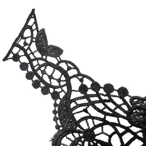 Vue macro détaillée montrant les motifs complexes d'une applique en dentelle noire brodée