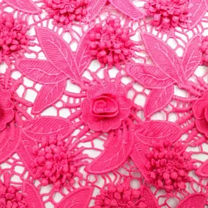 Close-up detail of fuchsia 3D floral water-soluble lace fabric with milk silk embroidery.