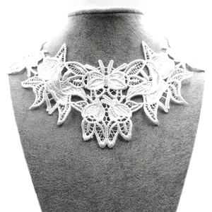 Detail view of white water-soluble lace embroidery with elegant butterfly patterns.