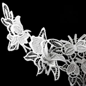 Detailed close-up of white water-soluble lace embroidery with intricate hollow patterns