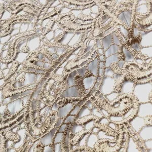 Makroansicht der komplizierten Details des beige wasserlöslichen bestickten Spitzenstoffs