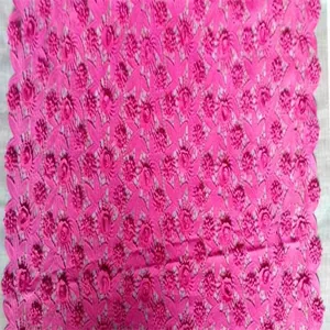 Detailed macro view of hot pink water-soluble lace fabric with 3D floral embroidery