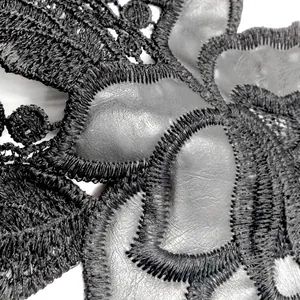 Macro detail of black water-soluble lace and grey PU leather embroidered applique