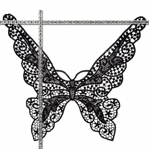 Macro detail view of black butterfly lace embroidery applique with size measurement tape