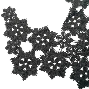 Close-up of black water-soluble lace floral applique with intricate embroidery details