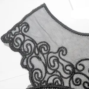 Close-up detail of black water-soluble lace embroidery on delicate mesh fabric for clothing