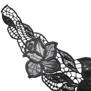 Detailed macro view of elegant black water-soluble lace with PU leather floral applique.