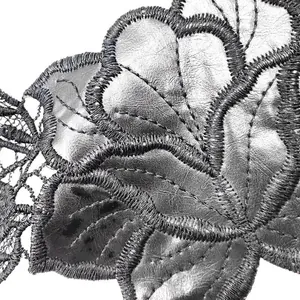 Close-up detail of water-soluble lace collar with metallic PU leather embroidery texture
