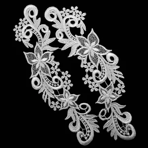 Detailed view of intricate white water-soluble lace flower patches for DIY sewing