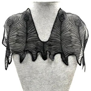 Vue détaillée du faux col en maille brodée noire avec motif de plumes de paon
