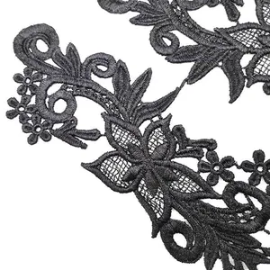 Close-up of black water-soluble lace embroidery with intricate hollow floral details