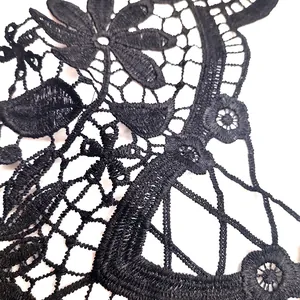 Close-up detail of black water-soluble lace embroidery with intricate floral patterns
