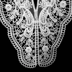Close-up detail of white water-soluble lace collar with delicate milk silk embroidery pattern