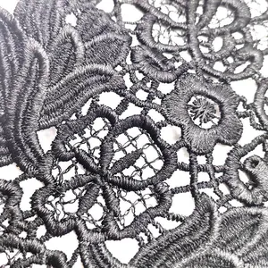 Detailed macro shot of exquisite black water-soluble lace with floral embroidery patterns