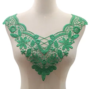Detailed green water-soluble lace floral embroidery appliqué on mannequin for DIY sewing.
