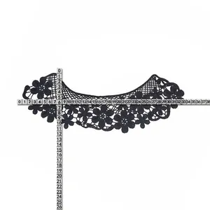 Macro view of black water-soluble lace floral collar applique with measurement ruler