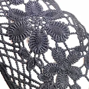 Close-up detail of black water-soluble lace with intricate 3D floral embroidery