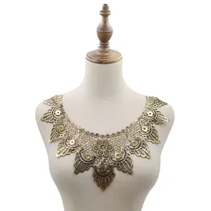 Vista detallada del cuello de encaje hidrosoluble dorado con bordado floral de estilo vintage