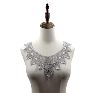 Vista detallada del cuello de encaje bordado gris soluble en agua en un maniquí
