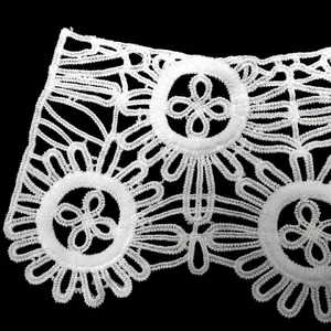 Macro view of white milk silk water-soluble lace featuring a floral embroidery pattern