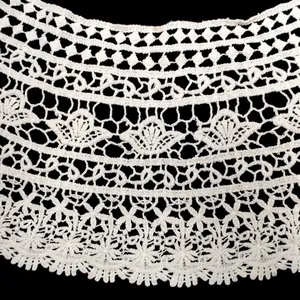 Detailed close-up view of delicate white crochet lace floral pattern on black background