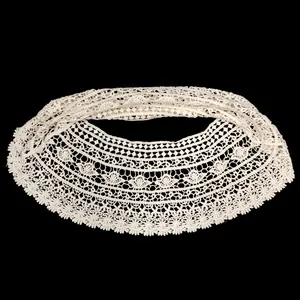 Detailed close-up showing the intricate white lace crochet hollow-out floral pattern on shawl