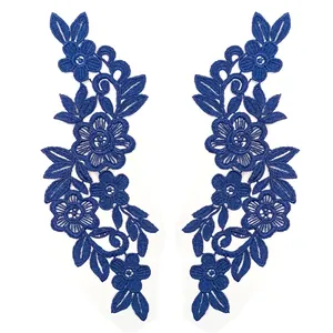 Detailed macro view of royal blue floral embroidery lace appliques on white background