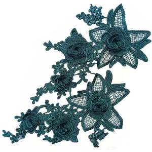 Macro view of dark green 3D embroidered lace applique with intricate floral details
