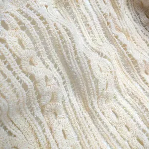 Macro view of the intricate hollow-out lace and embroidery texture of the cotton vest top