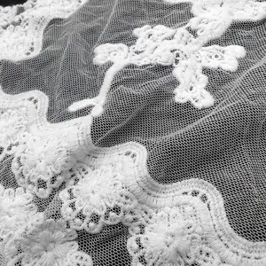 Macro detail of white cotton water-soluble lace fabric with floral embroidery pattern