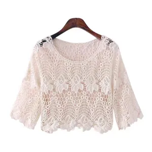 Detailed view of white hollow-out crochet knit top with elegant floral lace pattern