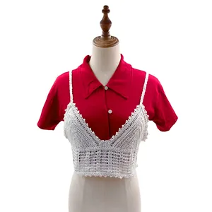 Vista dettagliata del camisole in pizzo all'uncinetto bianco su una camicia rossa.