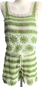 Vue détaillée d'un ensemble en crochet vert et blanc sur un mannequin avec motifs ajourés