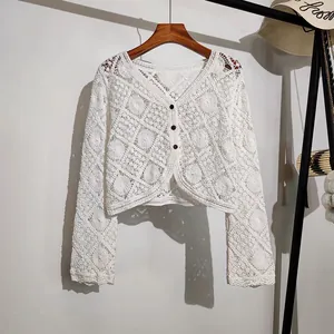 Close-up of white bohemian crochet lace cardigan with hollow floral embroidery details