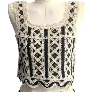 Detail view of black and white crochet knit crop top with intricate hollow embroidery