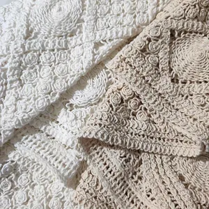 Close-up detail of Bohemian hollow-out embroidered lace fabric in white and beige