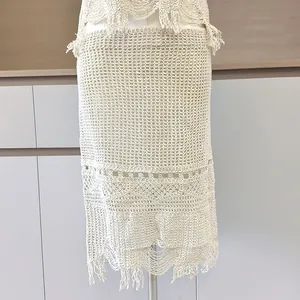 Gros plan sur une jupe en crochet vintage beige avec motifs ajourés et franges