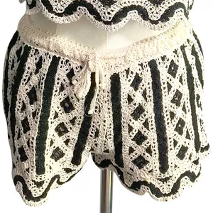 Close-up detail of black and white hollow out crochet knit shorts with wavy scallop hem