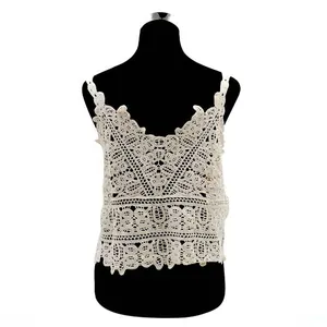 Close-up of white crochet lace camisole featuring intricate hollow-out floral embroidery