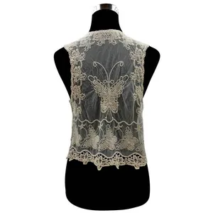 Dettaglio retro del gilet in pizzo bianco con ricamo a farfalla e bordi a festone.